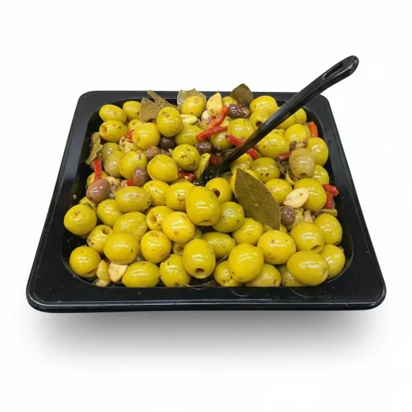 Tray of bright pickled green olives mixed with garlic, bay leaves, and red pepper slices