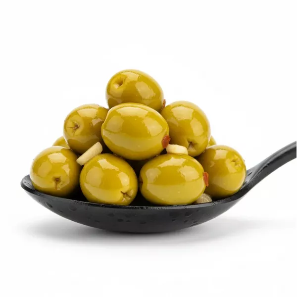 Close up of shiny marinated green olives in a spoon
