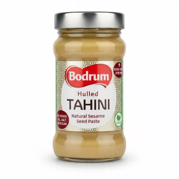 Glass jar of Bodrum Hulled Tahini with silver lid on white background