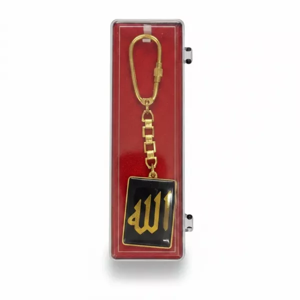Gold-coloured keychain with Arabic calligraphy on black background in display box