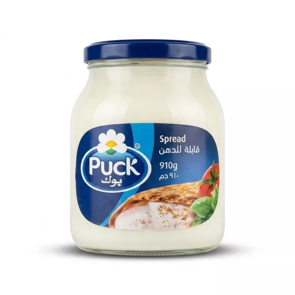 Enhanced Front view of Puck Cheese Spread 910g jar held in hand in supermarket aisle