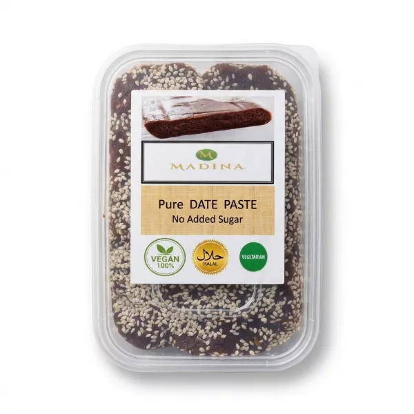 Enhanced Hand holding a container of Madina Pure Date Paste with sesame seeds and clear labelling for vegan, halal, and no added sugar