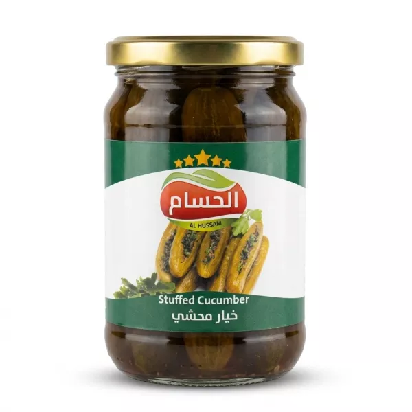 A professional front view studio shot of a glass jar of Al Hussam Stuffed Cucumber with a green and white label and a gold lid, centered on a plain white background with soft shadows.