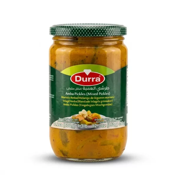 A 600g glass jar of Durra Amba Mixed Pickles with a green label and a spotted lid, shown in a front view against a clean white background. PRODUCT TITLE: Durra Amba Mixed Pickles PRODUCT: Durra Amba Mixed Pickles, 600g, front view jar, against a clean white background with professional studio lighting.