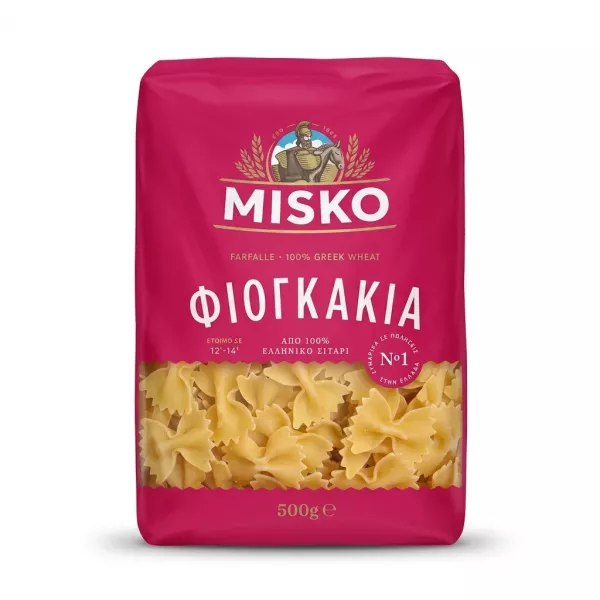 A 1:1 professional e-commerce product photograph showing a single 500g package of Misko Farfalle pasta against a clean, white background. The bright magenta package is centered, featuring clear Greek and English text, with a transparent window at the bottom revealing the bow-tie-shaped pasta. There are no tags or labels, and the lighting is even and sharp with a soft, symmetrical shadow.