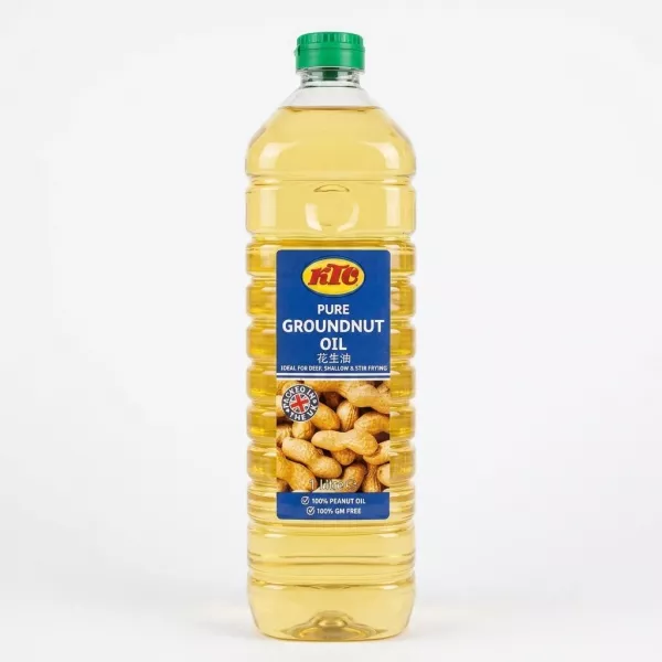 A 1-liter bottle of KTC Pure Groundnut Oil with a clean blue label featuring the red and yellow KTC logo, peanut illustrations, and '100% GM FREE' text. The bottle has a green cap, ribbed clear plastic, and contains golden groundnut oil, standing against a pure white background with soft, even shadowing.