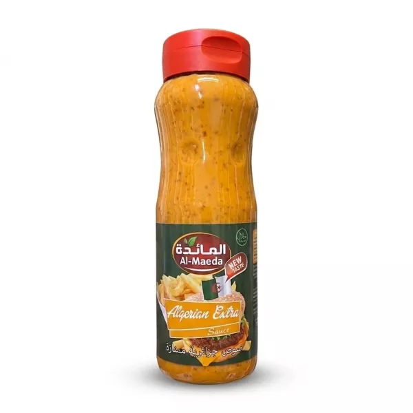 Enhanced A 1:1 professional e-commerce product photograph of a 500ml Al-Maeda Algerian Extra Sauce bottle, held by a hand against a clean, pure white background. The bottle is perfectly centered, sharply in focus, and features clean, clear branding, showing the orange-colored sauce and the label with images of a burger and fries and text in Arabic and English. PRODUCT TITLE: Al-Maeda Algerian Extra Sauce 500ml This professional e-commerce image shows the Al-Maeda Algerian Extra Sauce bottle held by a clean hand, isolated against a seamless, pure white background. The bottle and hand together are centered, occupying 85% of the frame. The focus is critically sharp on the bottle and the hand, highlighting the texture of the sauce and the details of the label. All price stickers, batch code ink, and background distractions from the original image have been cleanly removed, while preserving all correct label text, branding, graphics, and the hand position. The lighting is soft, diffuse professional studio lighting, which ensures no harsh reflections on the bottle or hand and renders a very soft, equal shadow beneath and around the entire subject on the white floor, giving it depth. The 1:1 aspect ratio ensures a perfect square frame for the clean presentation. The label details, including the Al-Maeda logo, "Algerian Extra Sauce" text, and the images of the fries and burger, are pristine and legible. The orange color of the sauce is accurate and vivid.