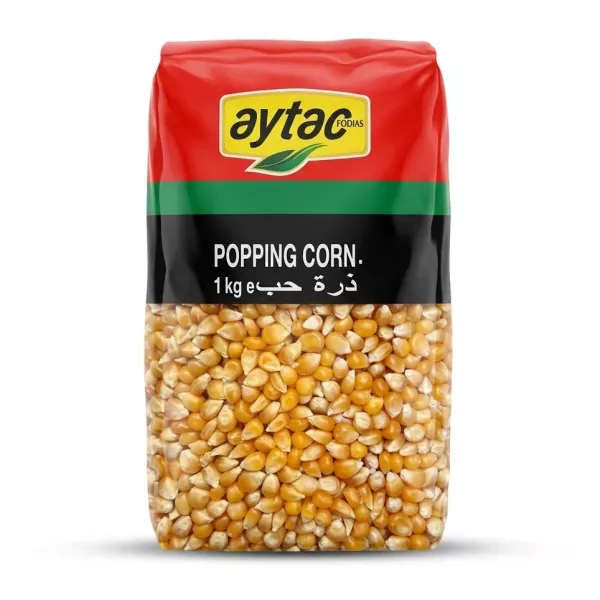 A 1kg bag of Aytac Premium Popping Corn, featuring the brand's logo, English text, and Arabic script against a vibrant red, yellow, and green package, with a clear window revealing the dried corn kernels inside.