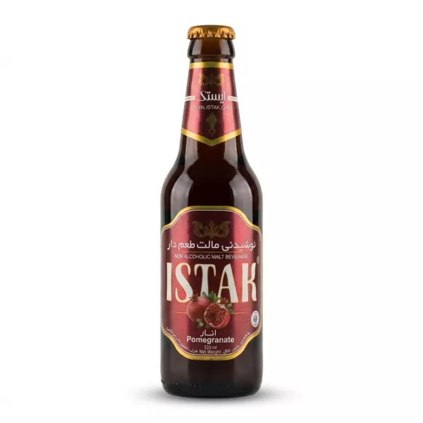 A 320ml glass bottle of Istak Pomegranate Non Alcoholic Malt Beverage is centered on a clean white background. It features a maroon and gold label with images of fresh pomegranates and the product name in large English and Arabic text.