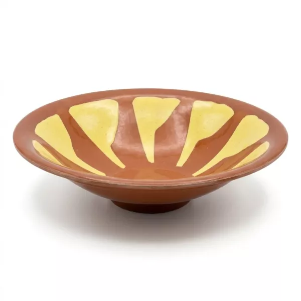 Enhanced Hand holding a decorative brown and yellow ceramic shallow bowl, side view