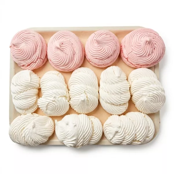 Tray of handmade white and pink meringue cookies with swirl design