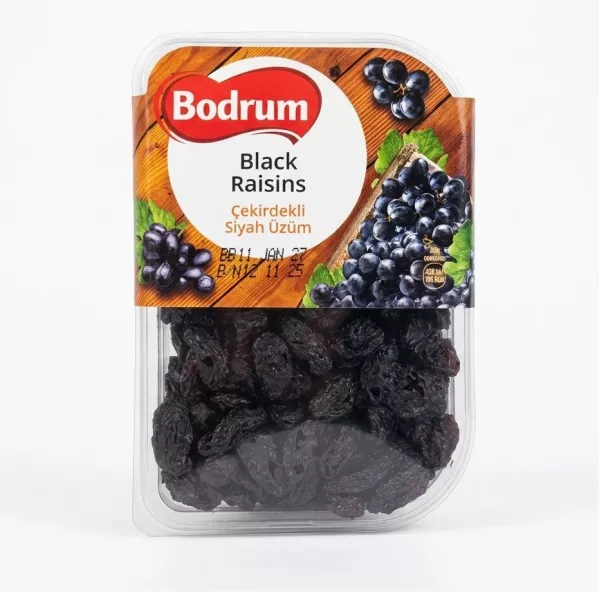 Hand holding a 250g pack of Bodrum Black Raisins with label visible