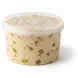 Side view showing pistachio pieces embedded in halawa inside transparent plastic tub
