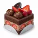 Close-up of rich chocolate berry cake slice topped with fresh strawberries, raspberries and dark chocolate swirl