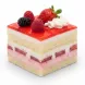 Close-up slice of strawberry berry layer cake with fresh strawberries, raspberries, and blackberries topped with whipped cream