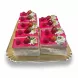Tray of multiple Mixed Berry Celebration Cake slices decorated with fresh berries, whipped cream and pistachios