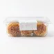 A clear plastic container of Dijla Food Coconut Maamoul pastries, showing three baked maamoul through the side with a white nutritional label. {image}
