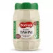 A front-facing studio shot of Bodrum Hulled Tahini in a 900g ribbed plastic jar with a green cap, featuring a clean white label. The jar is centered against a seamless white background with a soft shadow at its base.