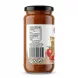 A professional e-commerce photo displaying the back label of a 465g glass jar of Sofra Roasted Garlic Pasta Sauce against a pure white background. The clear label shows complete nutrition facts, product origins, and a barcode, all in sharp focus under soft studio lighting. [Scene: A 1:1 professional e-commerce product photograph.] [Subject: A perfectly clean and centered glass jar, featuring its back label, of Sofra Roasted Garlic Pasta Sauce. The jar fills approximately 85% of the frame and is presented from a direct-on perspective, replacing the original angled hand-held view.] [Label Details: The white paper label is perfectly affixed, clean, and in sharp focus. All text is legible and factually accurate to `image_0.png`:] - [Top:] The header 'Nutrition Information' and table below. All values (Per 100 g: Energy 277 kJ/66 kcal, Fat 4.1g, of which saturates 0.4g, Carbohydrate 5.8g, of which sugars 2.5g, Protein 0.9g, Salt 3.0g) are clear and legible. - [Middle:] All origin and distribution text is sharp: 'Product of Turkey', 'Distributed by:', 'DAMASGATE WHOLESALE', '7 DERBY ROAD, GREENFORD', 'MIDDLESEX, UB6 8UJ - UK', 'www.damasgate.co.uk'. - [Lower Middle:] The large barcode with the numbers `5 060997 026419` is clean and scannable. - [Bottom:] The three circular icons (Fork & Knife, Recycle, Bin) and the '465g' weight are all sharp and visible. The partially visible red tomato slice and the 'Ro...' from the main title are visible to the right of the nutritional table and barcode, as seen in `image_0.png`. - [Imperfection Removal:] There are no tags, labels, or stickers on the glass or label that do not belong to the primary product label. The small pink sticker and any other obstructions are removed. [Jar Details:] - The glass jar itself is pristine, showing the rich, chunky texture of the roasted garlic sauce. - The glossy black lid is clean. - The liquid level is natural. [Lighting & Environment:] - [Lighting:] Professional, soft, diffuse studio lighting that evenly illuminates the entire product and label, making text and texture highly legible. There are soft, controlled specular highlights on the glass and lid, giving it a premium feel without obscuring information. - [Shadows:] A very soft, diffuse contact shadow is visible on the clean white background surface directly beneath the jar, extending equally on both the left and right sides. - [Background:] The background is a clean, pure, seamless white studio void. No grocery shelves or hands are visible. [Focus:] - The entire jar and, crucially, all text on the label are in razor-sharp focus from the top of the lid to the bottom of the weight. [Composition:] - A clean, symmetrical front-on view of the jar, centered perfectly within the 1:1 square frame.