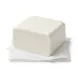 ** A studio photograph of a centered, white block of Milky's Reduced Fat White Sour Cheese with a smooth, compact texture, presented on a white folded paper wrap.