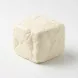A professional studio photo of a square block of white, unwrapped Halloumi cheese. The cheese block, with its natural texture and shape, is presented on a clean white surface with a soft, even shadow, showing the product in clear detail.