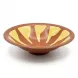 Enhanced Hand holding a decorative brown and yellow ceramic shallow bowl, side view