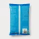 A professional studio photograph showcasing the back of the TRS Desiccated Coconut Medium pack. The bright blue packaging is clean, well-lit, and centered on a seamless light grey background, prominently displaying the multi-lingual ingredients, detailed nutritional information table, and specific batch details including the 12/2027 best before date and barcode. The clear central window reveals the shredded coconut inside.