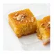 Close-up of Sultan Basbousa semolina cake slice showing moist texture and nut topping