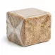Hand holding a block of natural African black soap wrapped in clear plastic